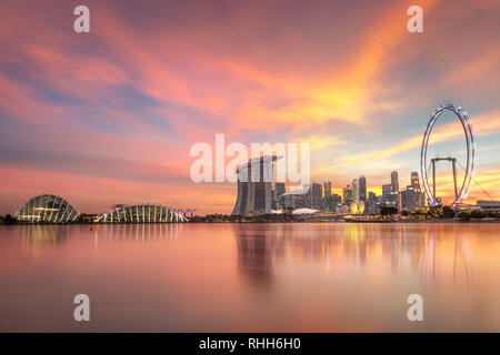 Gorgeous Singapore Skyline with illuminations. Singapore`s business district, marina bay sand and the garden by the bay on sunset. Stock Photo